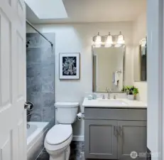 The hall full bath is updated with tile surround shower/tub and a skylight filling the space with natural light.
