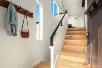 The door opens up to a spacious greeting area with wood flooring and vaulted ceilings.