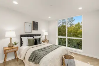 Wake up to the sun streaming through floor-to-ceiling windows. This bedroom offers a cozy, serene space to recharge and start your day refreshed.