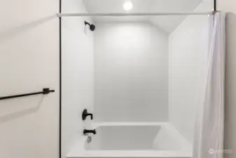 Unwind in this minimalist bath. Fresh white tiles and matte black fixtures create a modern, spa-like feel.