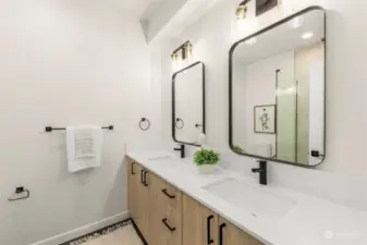 A sleek double vanity offers plenty of space for morning routines. This bathroom has stylish mirrors and contemporary fixtures and is all about modern elegance.