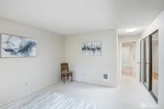 If you look to the right, you can see the large closet in primary bedroom, with hanging racks and shelving inside.