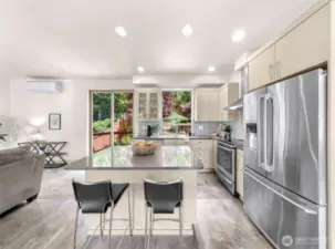 Beautiful kitchen with an island, quartz countertops, stainless steel appliances, gorgeous backsplash.