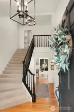 Inviting hardwoods, open rail banister and vaulted ceilings adorn the entry.
