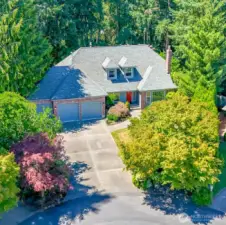 Aerial view showing the long, broad driveway leading to the 3-car garage.