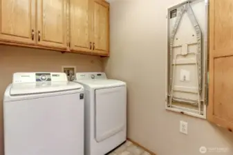 Handy laundry room with storage cabinets - even a hideaway ironing board!