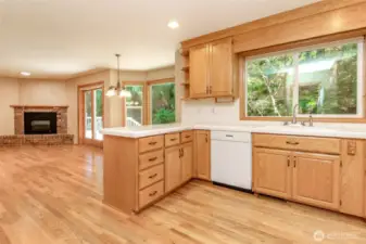 Kitchen looking through to the great room and 2nd gas fireplace with brick hearth. You can see the doors leading out to the expansive back deck.