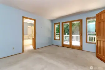 Primary bedroom with doors leading out to the back deck.
