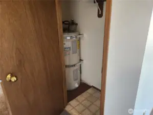 Water heater in hallway closet by entryway.  Still room for storing items.
