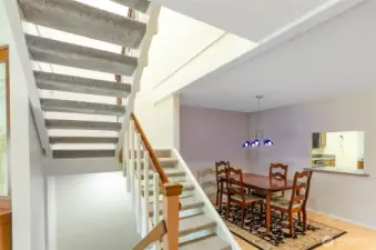 Open staircase lead to upper and lower living spaces.  Dining room has window access to kitchen.