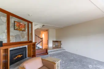 This view of the living room shows hallway entry and stairwell.
