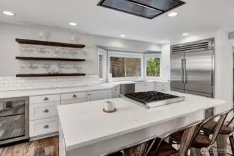 High end appliances including Sub Zero and Wolf. Notice the wine cooler on the left of this photo. Also note the built in vent hood into the ceiling. Quartz counters and soft close drawers