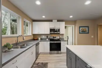Large windows provide natural light for every task; SS appliances add the shine. Doorway opens into handy laundry room.