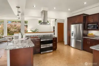 Re-imagined kitchen offers granite counters, cork floors, and stainless appliances.