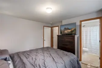 Primary bedroom showing walk in closet and full bathroom.