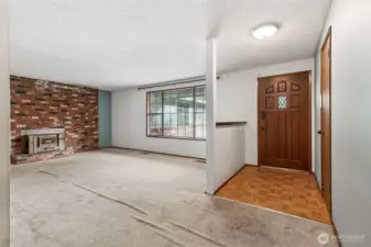 As you enter the home, you will find a parquet flooring entry with coat closet leading into a huge living room with natural floor-to-ceiling fireplace with electric insert.