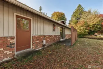 Side yard, patio with fence and garage man door.