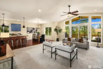 Open living area with vaulted ceilings and floor to ceiling windows.