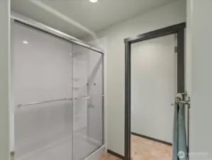 Extended Bath Fitter brand shower to right of tub. Doorway to toilet rm.