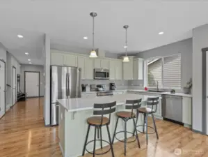 Slab quartz counters and stainless steel appliances including gas range.