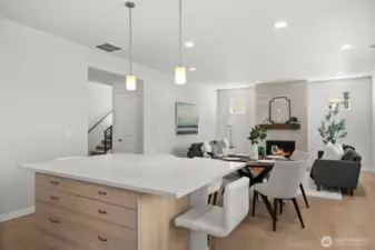 Upgraded wood-toned cabinetry beneath the island adds valuable storage while creating a seamless visual flow with the flooring for a stunning presentation.