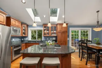 Well-appointed kitchen with stainless steel appliances, convenient eating bar, and skylights to let the brightness in.