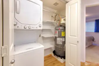 In unit washer and dryer stay with the home. Located in the oversized utility closet complete with shelving and a newer hot water tank installed in 2020