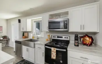A bright, contemporary kitchen featuring stainless steel appliances, ample cabinet space, and a versatile island for extra prep or seating.
