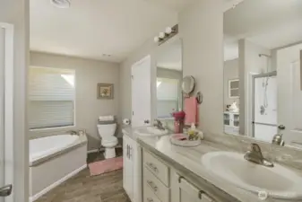 Enjoy a dual-sink vanity, soaking tub, and walk-in shower in this beautifully appointed ensuite with connected walk-in closet.