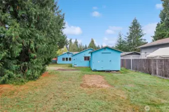 View of house from backyard w/ extra shed located behind garage