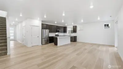 Bright open-concept main level with seamless flow between living, dining, and kitchen spaces.