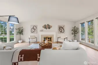 Living room vaulted ceilings, cozy wood-burning fireplace and over-sized windows on both sides.