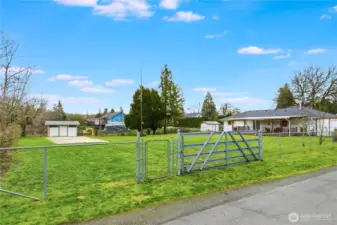 There is vehicle access to the oversized backyard and cement slab from the side street. Shown here is the gate for entry.