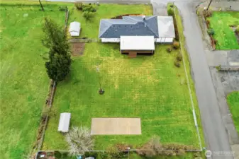 This aerial view shows off the backyard of the home, the size of the cement slab, and the layout of the property.