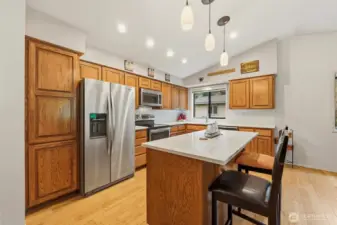 Kitchen showcasing unique angles, beautiful cabinetry, and a welcoming island that anchors the space with both style and function.