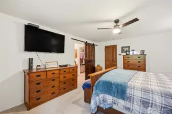 Primary suite with stylish barn doors leading to the bath and closet, adding character and a distinctive design touch.