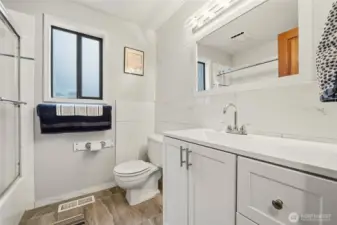 Guest bath with tile flooring and a clean, crisp vanity accented by marble details, offering a fresh and polished look.