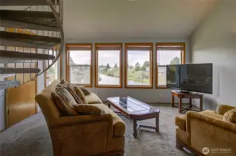 There is storage behind the wood door, and the spiral stairs lead to the primary suite and loft.