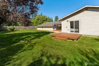 Sliding door from primary bedroom to a newly stained deck.