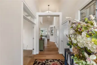 Step into an airy, inviting entrance defined by soaring vaulted ceilings and rich engineered hardwood floors. Crisp white trim and a graceful architectural arch draw your eye down the hall, creating a sense of openness and flow.