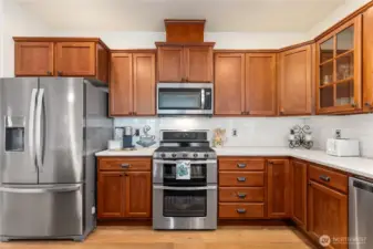 Stainless appliances, a 5-burner gas range, double ovens, quartz counters and subway tile are all enhancements that elevate this kitchen.
