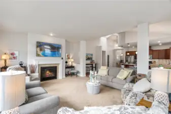 Plush carpeting and soft neutral tones create a cozy atmosphere, complemented by multiple seating arrangements ideal for conversation or quiet relaxation.