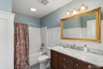 Charming hall bathroom with custom vanity, trim and tile floors.