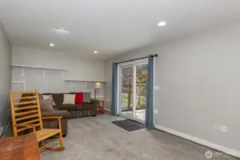 Rec room on the lower level with slider to lower deck and the fully fenced back yard