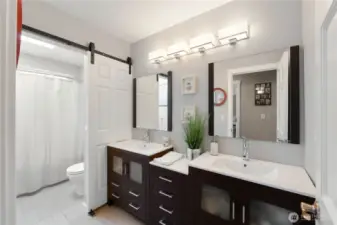 Large bathroom upstairs with double vanity, barndoor separating the tub/shower and toilet for privacy