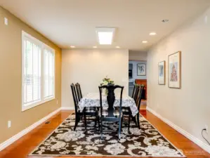 Formal dining room with hardwood floors leading to kitchen.