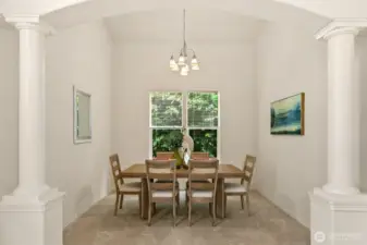 Formal dining room flanked by dramatic columns.