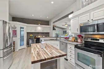 Light, bright, chef's kitchen with stainless appliances and pantry