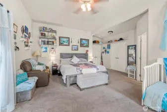 Large primary bedroom with large walk-in closet, large en-suite bathroom attached, sliding glass doors to back deck