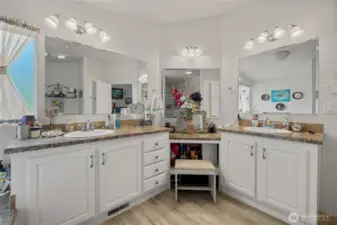 Primary en-suite bathroom with double sinks, soaking tub, shower and extra storage space